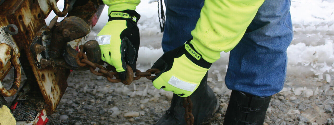 Man wearing Youngstown High Visibility (High Viz) Gloves working on rusty chain
